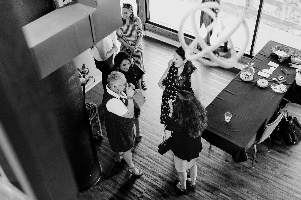 black and white image of business owners speaking at a networking event, taken from second floor balcony